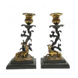 A pair of Regency patinated and gilt bronze candlesticks,