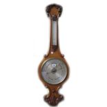 A Victorian oak cased wheel barometer with applied thermometer over a 9.