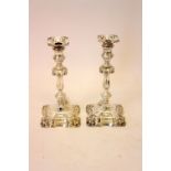 A pair of George II style silver candlesticks, Hawksworth Eyre Ltd, Sheffield 1911 & 1912,