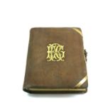 A Victorian brown suede leather photograph album, with applied gilt metal monogram and clasp,