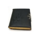 A Victorian black leather Favourites of the Forest photograph album, with metal clasp,