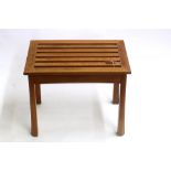 A walnut luggage stand by Brynmaw Furniture, the rectangular slatted top on chamfered flared legs,
