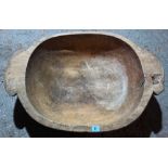 A large dug-out wooden bowl.