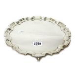 A silver salver, of shaped circular form, in the Chippendale style, with a pie-crust rim,