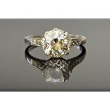 A platinum and diamond ring, claw set with the principal cushion shaped diamond at the centre,