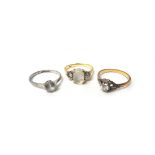 A gold and platinum, diamond set single stone ring, claw set with a circular cut diamond,