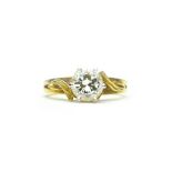 A gold and diamond set single stone ring, claw set with a circular cut diamond,