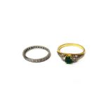 A gold, emerald and diamond set three stone ring,