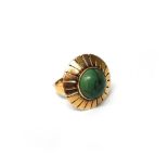 A gold and turquoise single stone ring, the single turquoise mounted in a radiating surround,