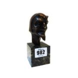 A small bronze bust, circa 1930, cast as the devil on a green vein marble plinth,