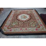 A French Aubusson carpet, the brown field with a floral bouquet in an ivory roundel,