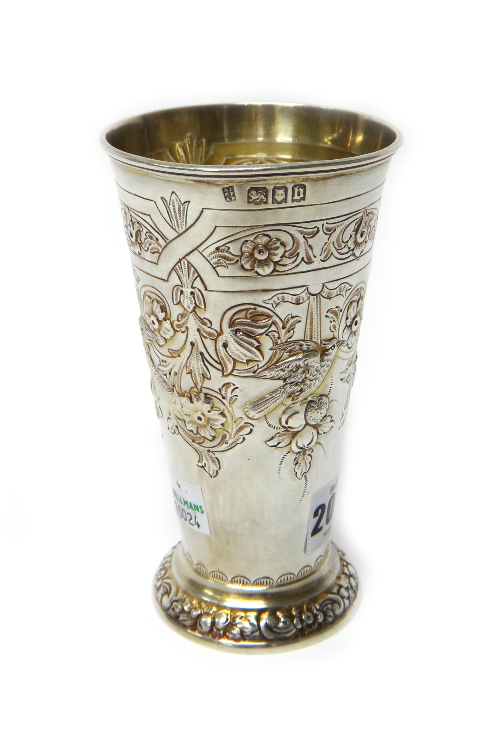 A silver vase, of tapering cylindrical form, embossed with birds, fruit and flowers,
