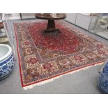 A Kashan carpet, Persian, the madder field with a bold indigo and black medallion,