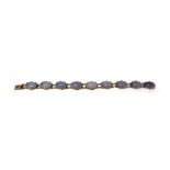 A gold mounted, dyed pale blue agate set bracelet, designed as a series of circular links,