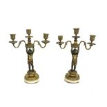 A pair of Victorian brass and marble mounted three branch figural candelabra,