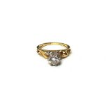 A gold and diamond set single stone ring, claw set with a circular cut diamond,