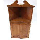 A late Victorian light oak wall hanging corner cabinet, with a recess above panelled doors,