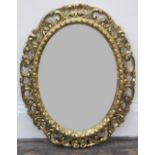 A Florentine giltwood oval framed mirror, 20th century, 97 x 75cm.