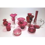 A collection of Victorian and later cranberry glasswares including two jugs,