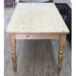 A pine kitchen table, 20th century, the rectangular top over four turned legs, 180 x 91 x 77cm.