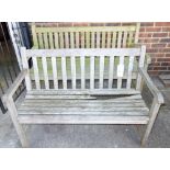 A 20th century teak slated garden bench and another similar.