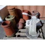 A group of garden decorative objects, including five terracotta chimney pots, two ball finials,