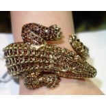 A gilt metal and paste hinged bangle by Roberto Cavalli, formed as an alligator.