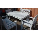 A pair of white painted garden benches, a table and a pair of armchairs,