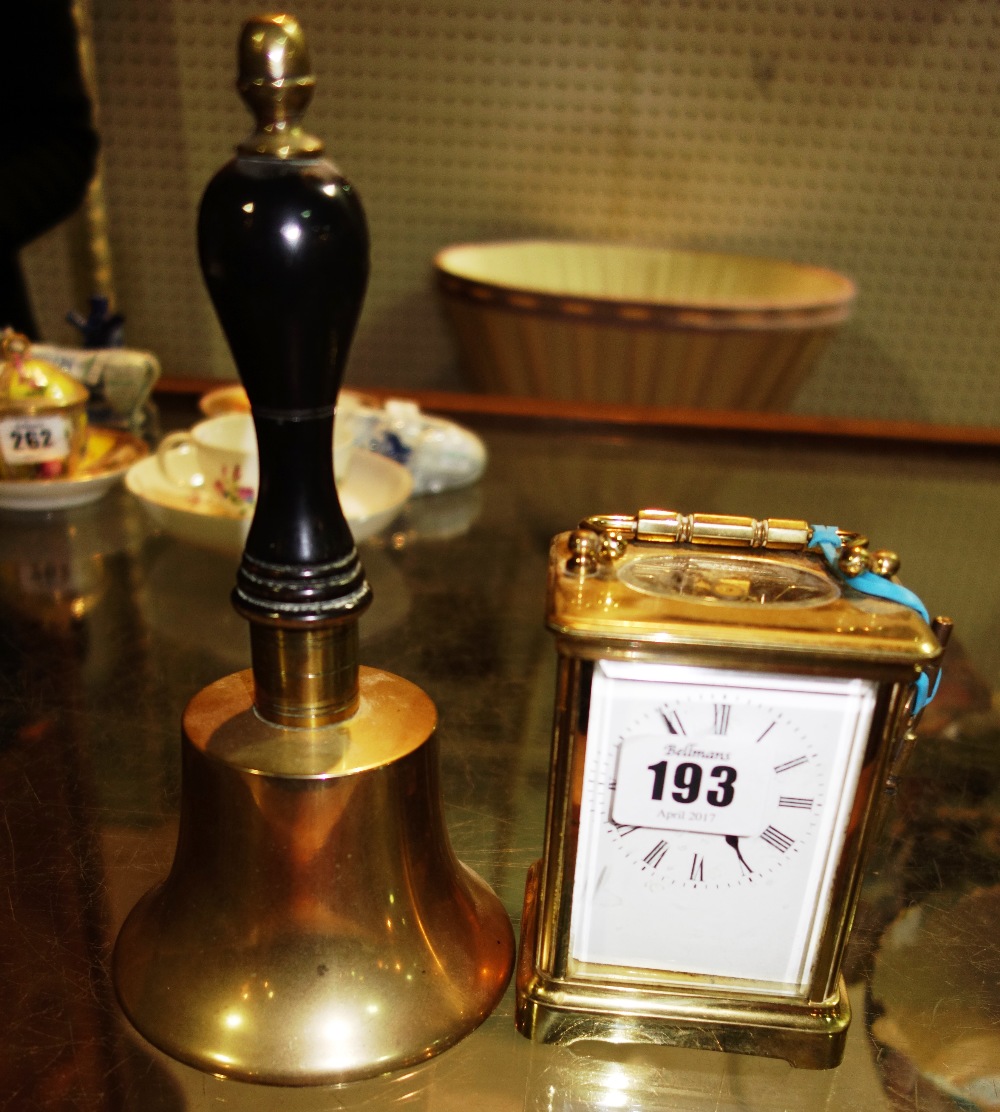 A 20th century brass cased carriage clock, together with a brass hand bell, (2).