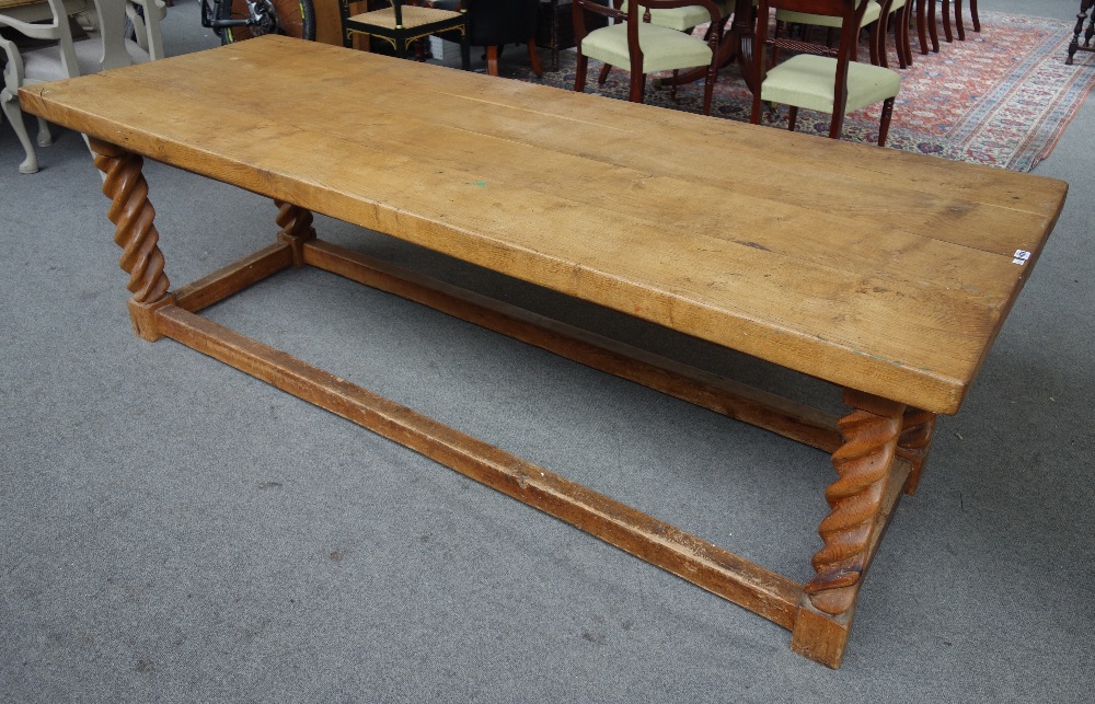 A thick oak four plank kitchen table, on a pitch pine base with barleytwist supports,