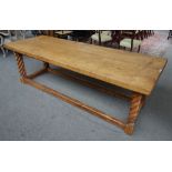 A thick oak four plank kitchen table, on a pitch pine base with barleytwist supports,