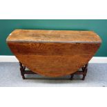 An 18th century oak gate leg dining table, on turned supports,