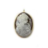 A gold mounted oval shell cameo pendant brooch, carved as the portrait of a lady, detailed 750.