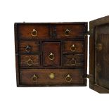 An 18th century oak spice cupboard, the single door enclosing eight drawers, 26cm wide x 16cm deep.