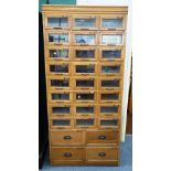 A 20th century oak haberdashery cabinet, with ten rows of three graduated glass fronted drawers,