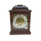 An Elliot walnut cased mantel clock with an eight day Westminster chiming three train movement,