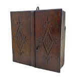 A Charles II oak hanging cupboard, with pair of carved doors and iron hanging hook,