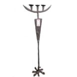 A cast iron three branch altar candlestick of contemporary stylized form 260cm high.