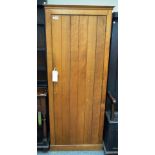 Heals; an oak hanging cupboard, with single plank door on a plinth base, 73cm wide x 176cm high.