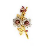 A two colour gold, ruby and diamond brooch, designed as a floral and foliate spray,