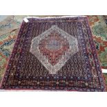 A Senneh rug, Persian, the black field with a bold madder and ivory medallion,