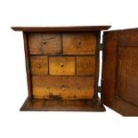 An 18th century oak spice cupboard, the deep fielded door enclosing six drawers,