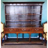 A mid-18th century oak dresser, the enclosed two tier plate rack over three frieze drawers,