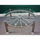 A 20th century coffee table, the circular glass top on a silver painted iron spoked wheel,