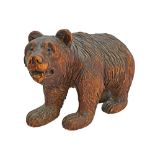 A Black Forest carved wooden bear, early 20th century, with glass eyes and open mouth,