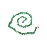 A single row necklace of graduated jade beads, on a boltring clasp, length of beads 62.5cm.