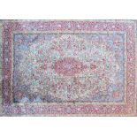 A Kerman carpet, Persian, the pale sage field with a bold madder medallion, pale indigo spandrels,