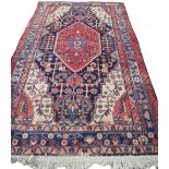 A Hamadan rug, Persian, the indigo field with a bold madder medallion, ivory spandrels,