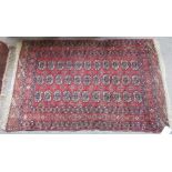 A Tekke Turkman rug, the madder field with three columns of nine guls, stylised crosses,
