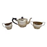 A silver three piece tea set, comprising; a teapot, a twin handled sugar bowl and a milk jug,